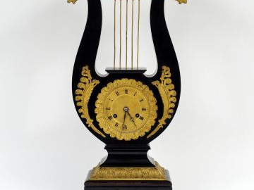 Pendule lyre Restauration en bois noirci et bronze doré, à décor de pa