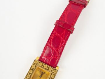 CHRISTIAN LACROIX. Montre femme, boitier carré doré à décor de gravure