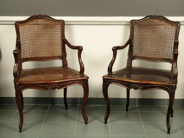 Paire de fauteuils cannés Louis XV en bois naturel, mouluré et sculpté