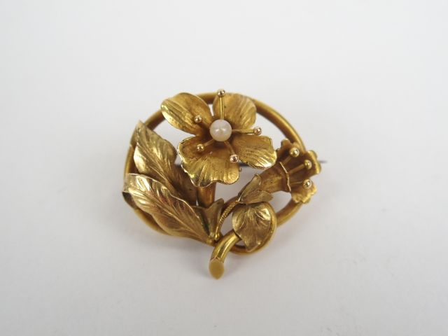 Broche en or jaune, à décor de fleur rehaussée d'une petite perle (piq