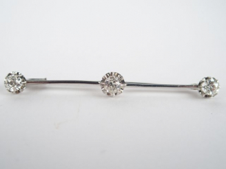 Vente aux enchères Broche en platine, ornée de 3 brillants entre 0,50 et 0,40cts environ.