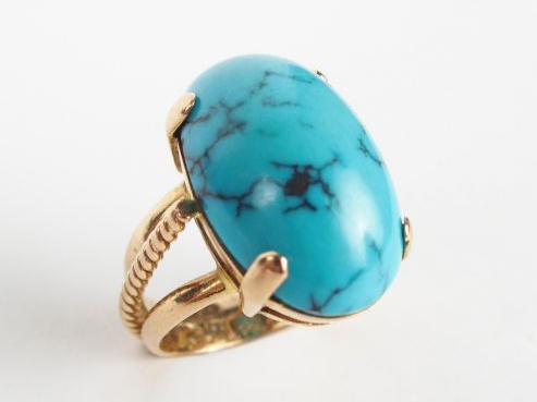 Bague 1900 monture or jaune, ornée d'une turquoise cabochon (charge de