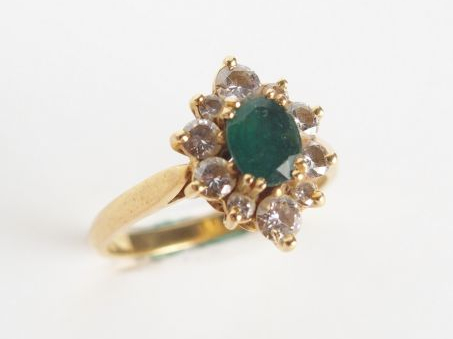 Bague en or, ornée d'une émeraude, entourage de petits diamants taille