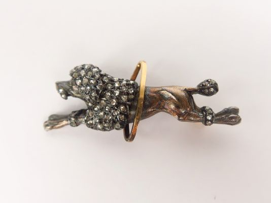 Broche en or jaune et gris à décor de caniche sautant à travers un cer