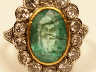Vente aux enchères Bague marguerite en or jaune, sertie d'une émeraude entourée de 14 dia