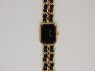 Vente aux enchères CHANEL. Montre de dame, bracelet en métal doré et cuir (usures)