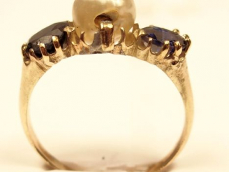 Vente aux enchères Bague en or jaune, ornée de deux saphirs entourant une perle baroque. 