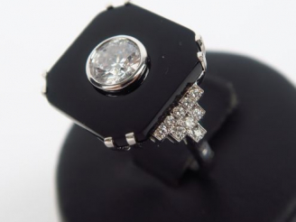 Vente aux enchères Bague en or gris, ornée d'une plaque d'onyx sertie d'un diamant de 1 c