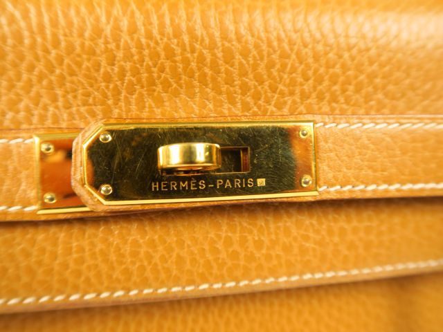 HERMES. Sac Kelly en cuir gold avec sa boite et son étui. L. 35 cm