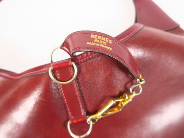 HERMES. Besace "Trim" en cuir bordeau (état d'usage).