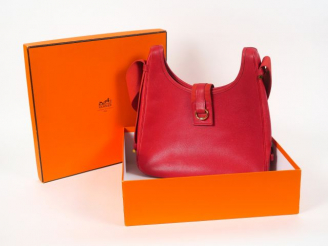 Vente aux enchères HERMES. Besace "Tsako" en cuir rouge avec sa boite (état d'usage)