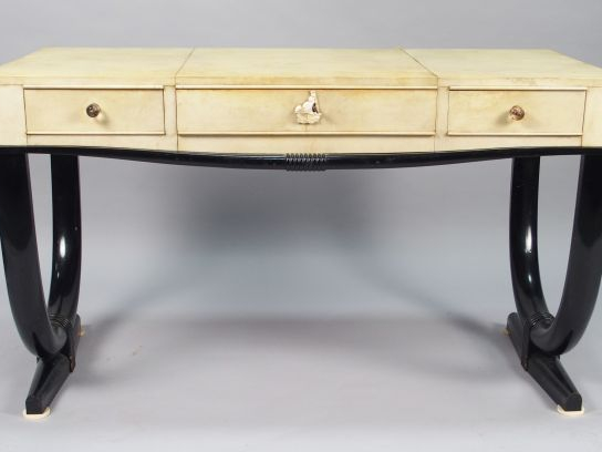 André ARBUS. Table bureau en parchemin et laque noire ouvrant à trois 