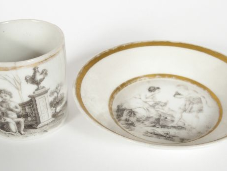 Tasse litron et sa sous-tasse Empire en porcelaine à décor en grisaill