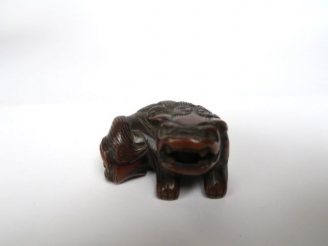 Vente aux enchères Netsuke en bois représentant un shishi couché, tenant une balle mobile