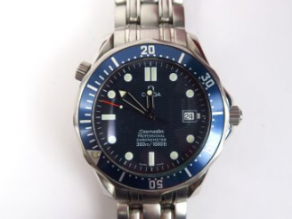 Vente aux enchères OMEGA. Montre en acier, modèle Seamaster. Dans son coffret (usures sur