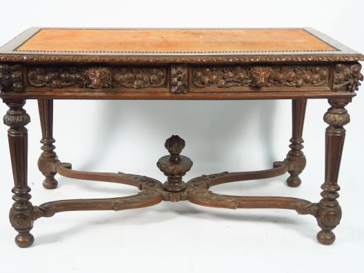 Bureau plat de style Henri II en chêne mouluré et sculpté, à décor scu