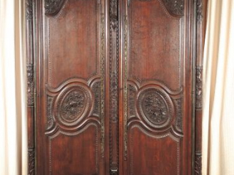 Vente aux enchères 	Armoire normande de style Louis XVI en chêne mouluré et sculpté à déc
