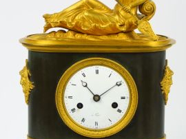Pendule borne Empire en bronze et bronze doré, surmontée d'une allégor