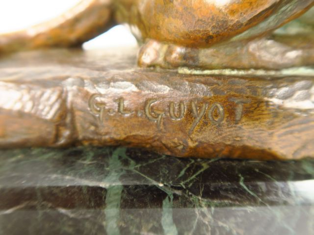 G.L. GUYOT. "Chien couché" Sculpture en bronze à patine brun vert, soc