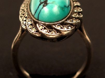 Bague en argent, ornée d'un turquoise en cabochon entourée de petites 
