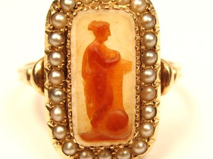 Bague en or jaune, ornée en son centre d'une cornaline figurant une je