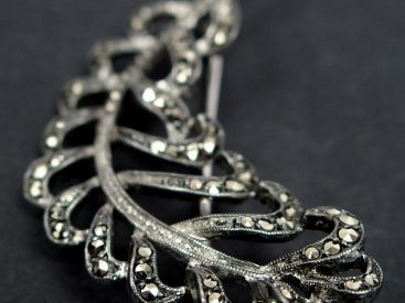 Broche en argent, en forme de feuille pavée de strass. 5cm Poids tel: 