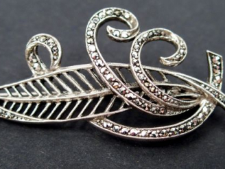 Vente aux enchères Broche en argent, en forme de plume et de volutes, pavée de strass. 6c