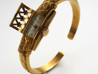 Vente aux enchères DELRIO. Montre bracelet en or gravé à décor de fleurs, cadran cage. Po