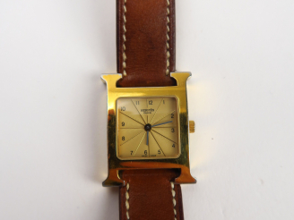 Vente aux enchères HERMES. Montre Heure H, cadran en acier plaqué or jaune (usures). Dans