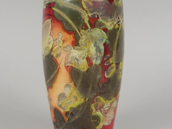 Vase en céramique, à décor de fleurs stylisées sur fond rouge rosé.  M