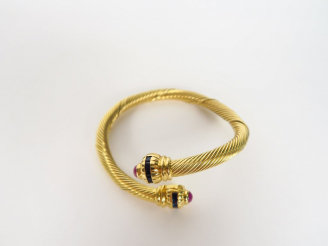 Vente aux enchères Bracelet torsadé en or jaune, orné de petits saphirs et de rubis en ca