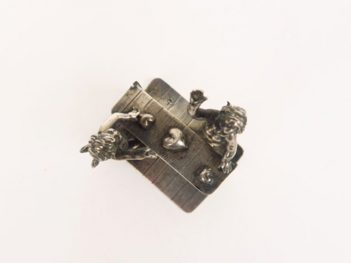 Sujet en argent 800 millièmes, à décor de deux amours.  Poids. 26,50 g