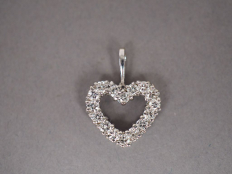 Vente aux enchères Pendentif en forme de cœur en or blanc, orné de seize petits diamants.