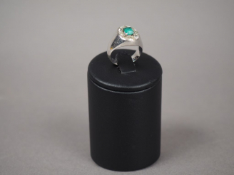 Vente aux enchères Bague chevalière en or blanc, ornée d'une émeraude entourée de roses. 