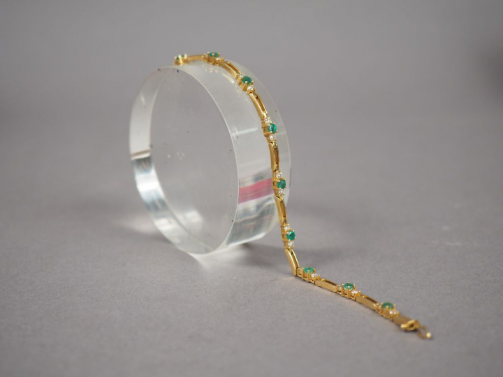 Bracelet articulé en or jaune, orné de onze émeraudes et de vingt-deux