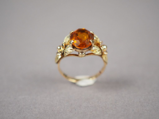 Vente aux enchères Bague en or jaune, ornée d'une citrine, monture à décor de fleurs.  TD
