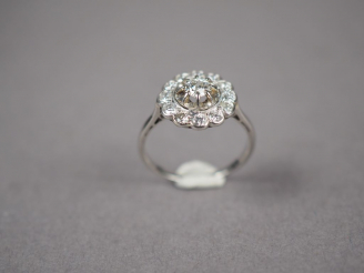 Vente aux enchères Bague marguerite en or blanc, ornée d'un diamant central entouré de do