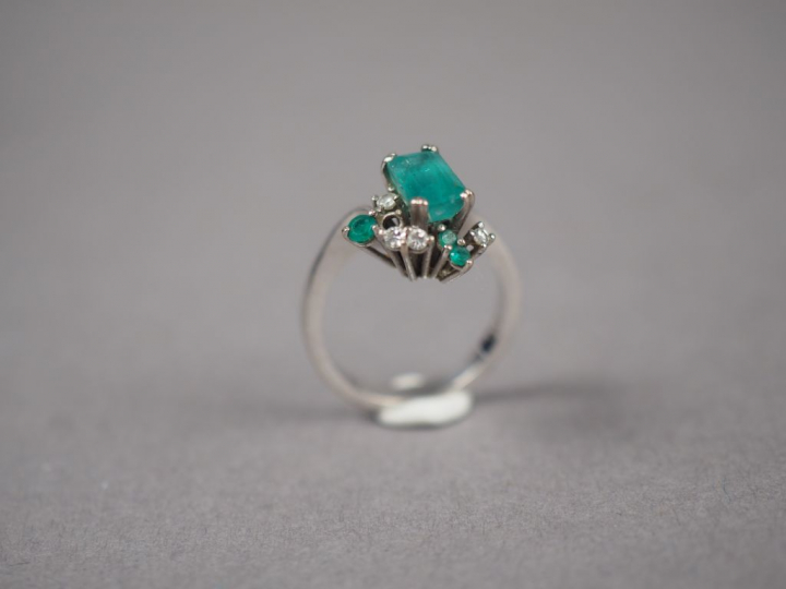 Bague en or blanc, ornée en son centre d'une émeraude entouré de quatr