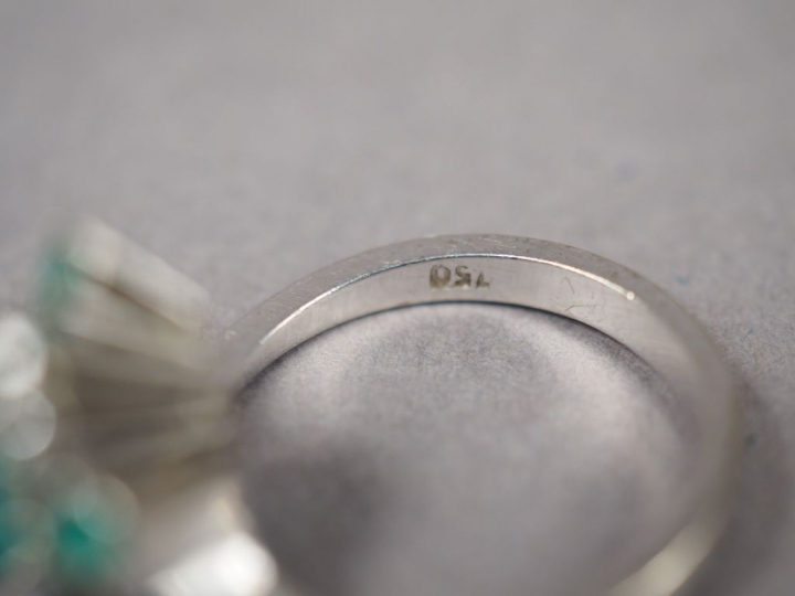Bague en or blanc, ornée en son centre d'une émeraude entouré de quatr