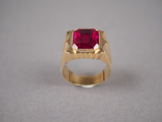 Vente aux enchères Bague en or jaune, ornée d'une pierre rouge synthétique.  TDD. 59 Poid