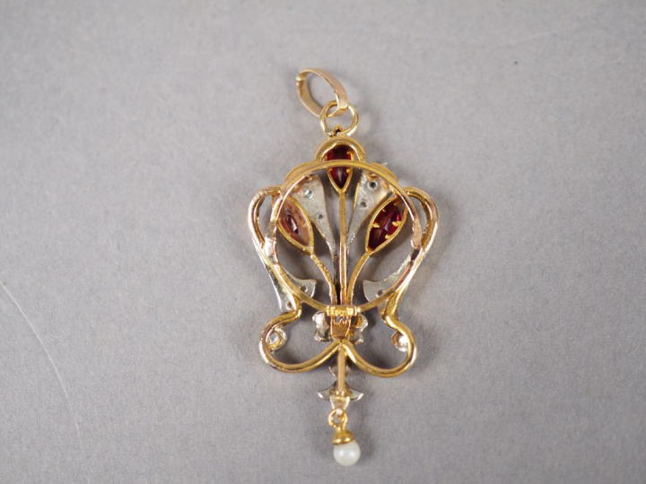 Pendentif en or jaune, orné de trois rubis, d'éclats de diamant et d'u