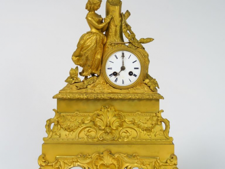 Pendule Restauration en bronze doré à décor de jeune fille romantique.