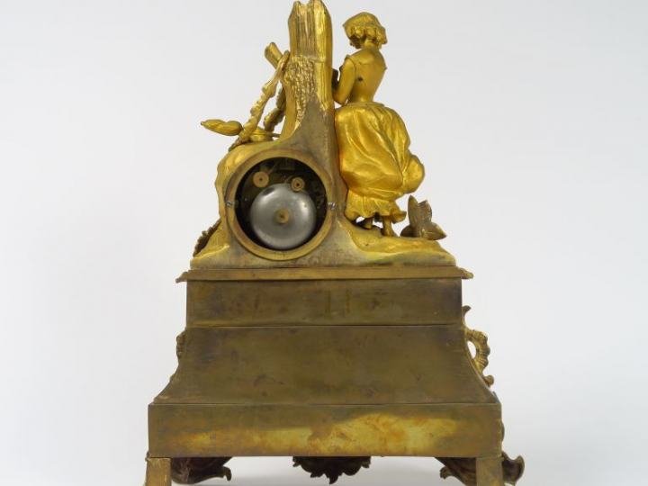 Pendule Restauration en bronze doré à décor de jeune fille romantique.