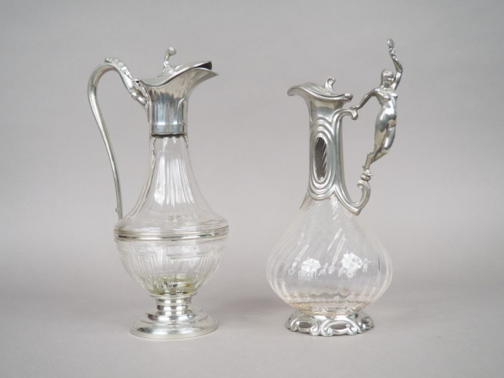 2 différentes aiguières en étain et cristal.  H. 31 et 31,5 cm