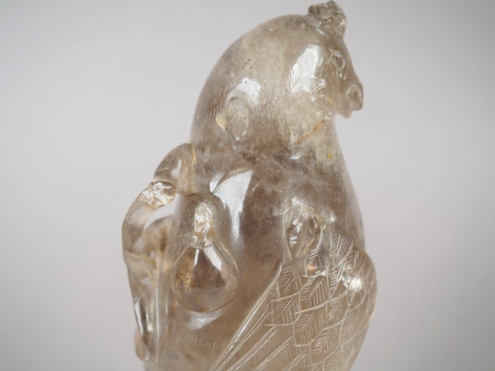 Statuette en cristal de roche fumé figurant une perruche posée sur un 