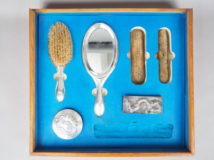 Partie de nécessaire de toilette en argent, à décor en relief de drago