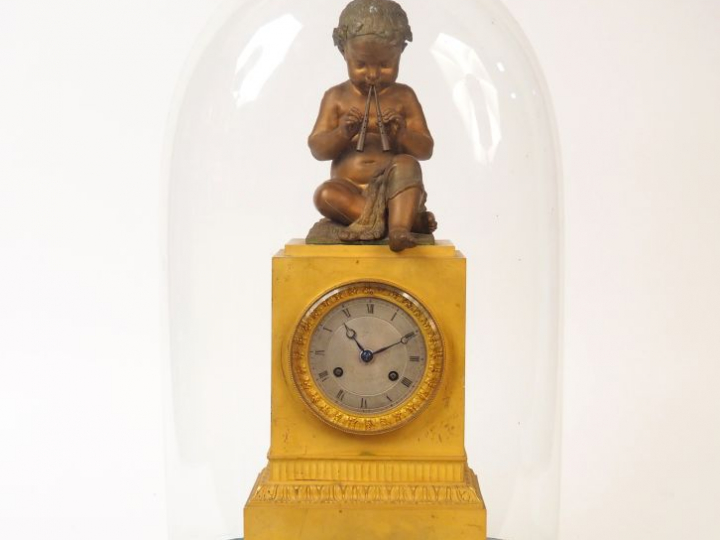 Pendule borne Restauration en bronze à patine médaille et doré, figura