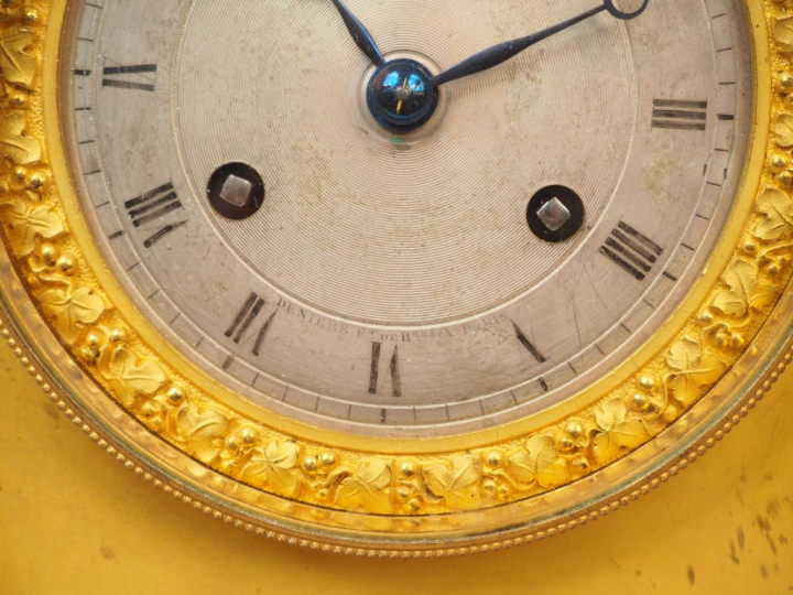 Pendule borne Restauration en bronze à patine médaille et doré, figura