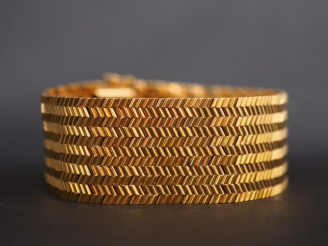 Vente aux enchères Bracelet manchette en or jaune, maille plate, à décor de motifs géomét