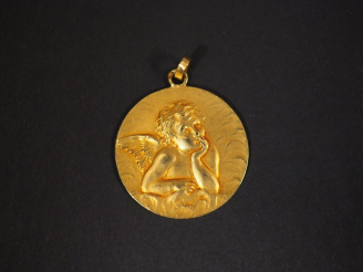 Vente aux enchères Médaille de baptême en or jaune, à décor d'un angelot.  Diam. 2,2 cm P
